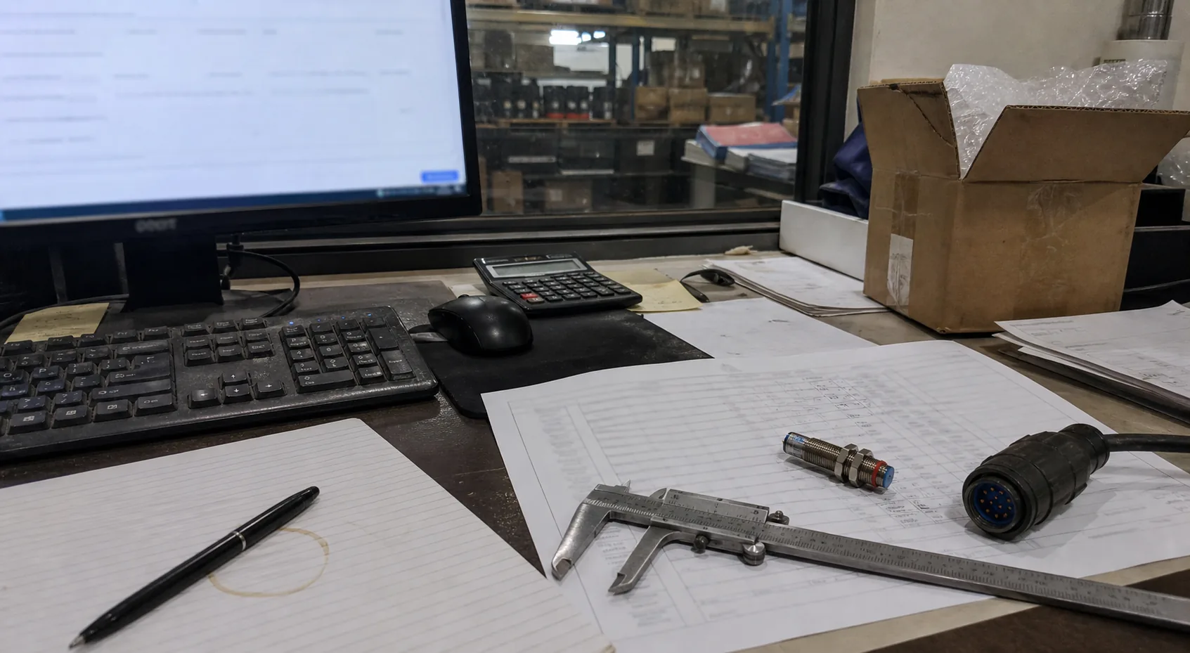 Industrial quotation paperwork and parts on a purchasing desk